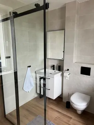 a bathroom with a shower and a toilet and a sink at Krollhouse Pokoje gościnne in Wolbrom