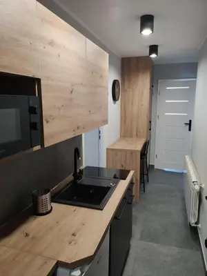 a kitchen with a sink and a wooden counter top at Krollhouse Pokoje gościnne in Wolbrom