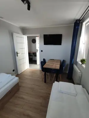a room with a table and a dining room at Krollhouse Pokoje gościnne in Wolbrom