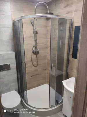a shower with a glass door in a bathroom at Krollhouse Pokoje gościnne in Wolbrom