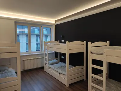 a room with three bunk beds and a window at Greg&Tom Hostel in Kraków