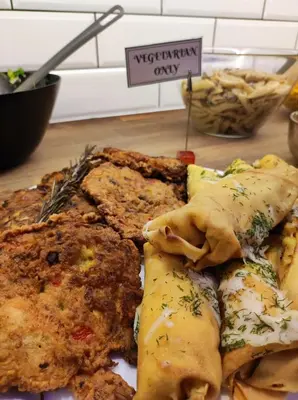 a plate of food sitting on a wooden table at Greg&Tom Hostel in Kraków