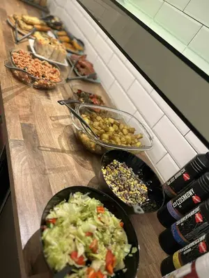 a counter with plates of food and bowls of food at Greg&Tom Hostel in Kraków