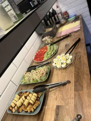 a buffet with plates of food on a counter at Greg&Tom Hostel in Kraków