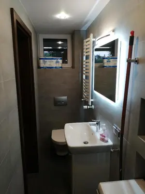 a bathroom with a sink and a toilet and a mirror at Andrychów Apartment in Andrychów