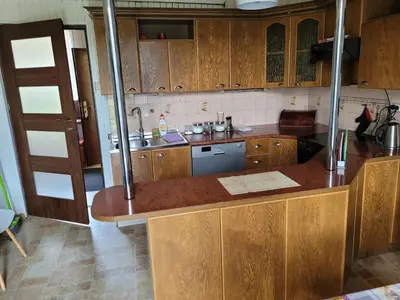 a kitchen with wooden cabinets and a counter top at Andrychów Apartment in Andrychów