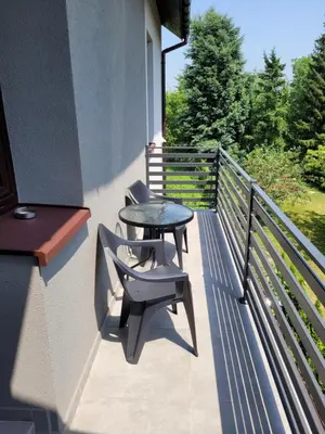 a patio with two chairs and a table on a balcony at Andrychów Apartment in Andrychów