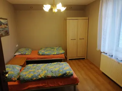 a room with three beds and a cabinet in it at Andrychów Apartment in Andrychów
