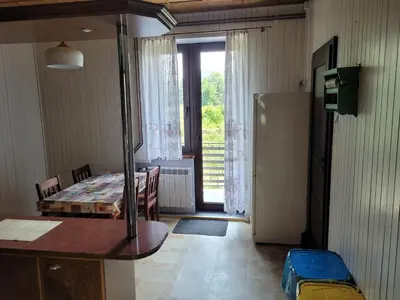 a room with a kitchen with a table and a refrigerator at Andrychów Apartment in Andrychów