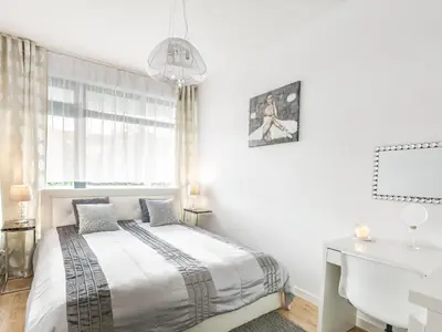 a white bedroom with a bed and a white desk at Golden Queen Apartments Jewish District in Kraków
