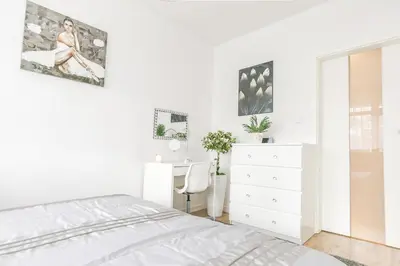 a white bedroom with a bed and a desk at Golden Queen Apartments Jewish District in Kraków