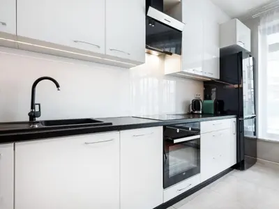 a white kitchen with white cabinets and a sink at Golden Queen Apartments Jewish District in Kraków