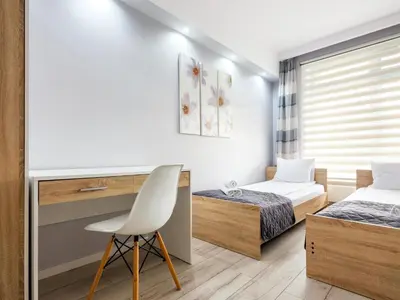 a bedroom with two beds and a desk and a chair at Golden Queen Apartments Jewish District in Kraków