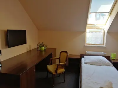 a bedroom with a desk and a bed and a tv at Pokoje Gościnne z łazienkami in Niepołomice