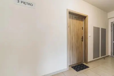 a hallway with a door with a sign on it at Studios Lubelska Kraków by Noclegi Renters in Kraków