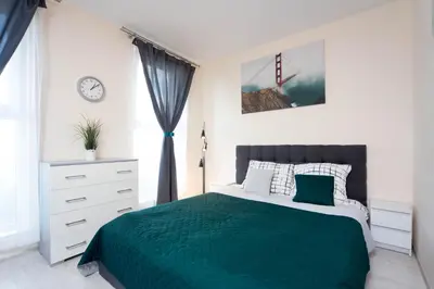 a bedroom with a bed with a green blanket at Cozy modern Apartment ASTORIA MAGIC GREY OLD TOWN in Kraków