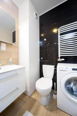 a bathroom with a toilet and a washing machine at Cozy modern Apartment ASTORIA MAGIC GREY OLD TOWN in Kraków