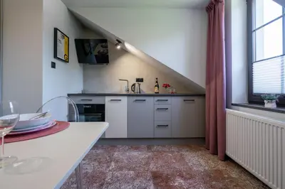 a kitchen with white cabinets and a table and a window at Carp&Bed Zator in Zator