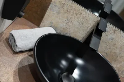 a bathroom with a black sink and a towel at Carp&Bed Zator in Zator