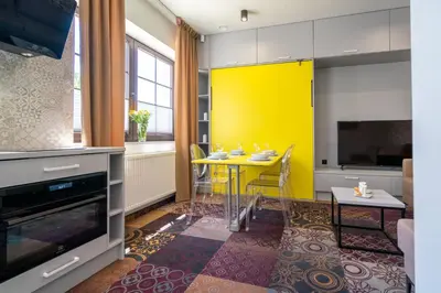 a kitchen with a table and a yellow wall at Carp&Bed Zator in Zator