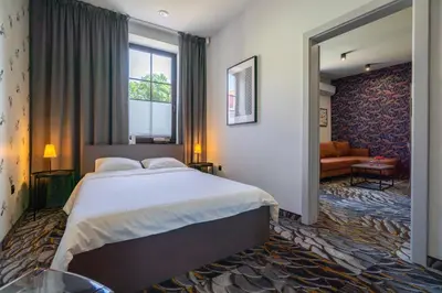 a bedroom with a large bed and a living room at Carp&Bed Zator in Zator