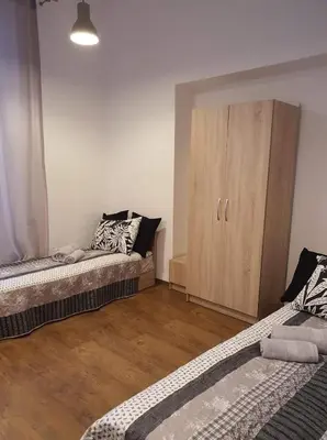 a room with two beds and a wooden cabinet at Schodami do Nieba in Kraków