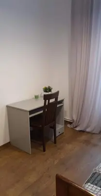a desk with a chair in a room with a curtain at Schodami do Nieba in Kraków