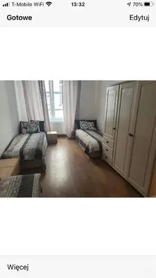 a living room with two beds and a cabinet at Schodami do Nieba in Kraków