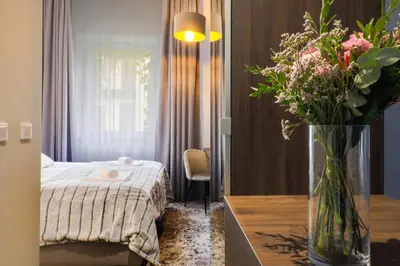 a bedroom with a bed and a vase of flowers on a table at Aparthotel Cracovia Residence in Kraków