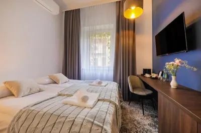 a bedroom with a bed and a desk and a television at Aparthotel Cracovia Residence in Kraków
