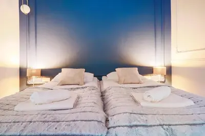 two beds in a bedroom with white sheets and pillows at Aparthotel Cracovia Residence in Kraków