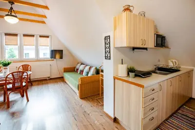 a kitchen and living room with a table and a couch at Orawskie Wyrko in Zubrzyca Górna