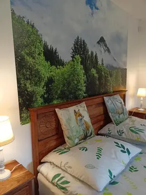 a bedroom with two beds and a painting on the wall at Nad Strumykiem in Mszana Dolna