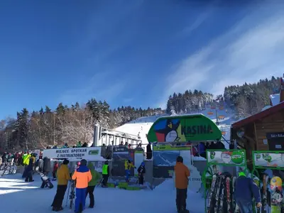 a group of people standing in the snow at a ski resort at Nad Strumykiem in Mszana Dolna