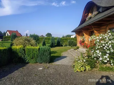 a house with a garden with white flowers in the yard at Górskie Marzenie - apartament w spokojnej okolicy z sauną blisko energylandii in Przeciszów