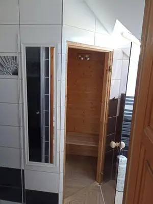 a bathroom with a shower and a glass door at Górskie Marzenie - apartament w spokojnej okolicy z sauną blisko energylandii in Przeciszów