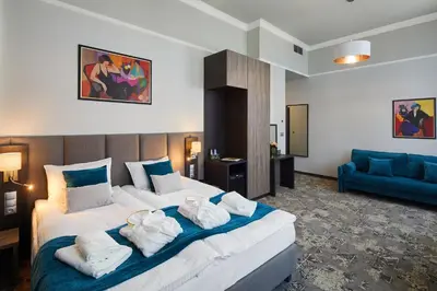 a hotel room with a large bed with towels on it at Hotel Estera in Kraków