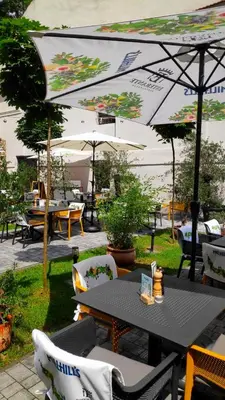 a patio with a table and chairs and umbrellas at Hotel Estera in Kraków