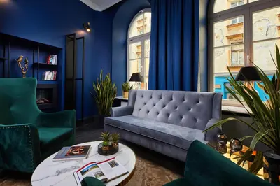 a living room with blue walls and a couch and a table at Hotel Estera in Kraków