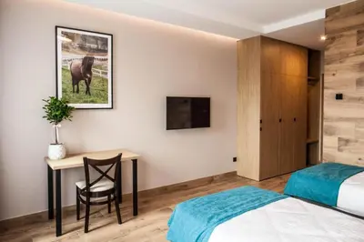 a bedroom with a bed and a desk and a table at Hotel Rancho Pcim in Pcim