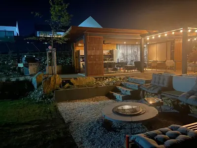 a backyard with a fire pit in the yard at night at villa relax with swimming pool and mountain view in Buków