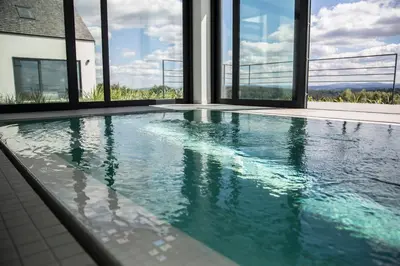 a swimming pool in a house with windows at villa relax with swimming pool and mountain view in Buków
