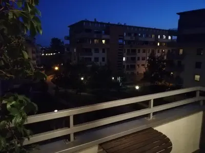 a balcony with a view of a city at night at W Krakowie u Helenki in Kraków
