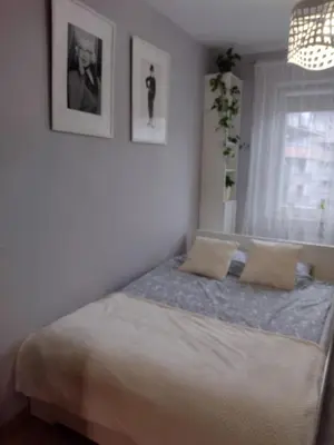 a bedroom with a bed with two pillows on it at W Krakowie u Helenki in Kraków