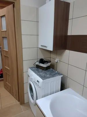 a washer and dryer in a kitchen with a cabinet at W Krakowie u Helenki in Kraków