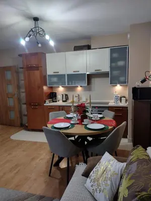 a kitchen and living room with a table and chairs at W Krakowie u Helenki in Kraków