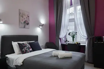 a bedroom with a large bed with purple walls at 7 HEAVEN Elegant Rooms KRAKÓW Old Town in Kraków