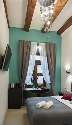 a bedroom with a bed with two white towels on it at 7 HEAVEN Elegant Rooms KRAKÓW Old Town in Kraków