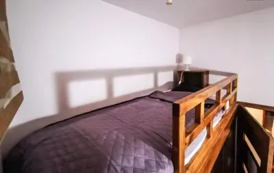 a bedroom with a wooden bed with a purple comforter at Cozy rooms in Old Town and Wawel in Kraków