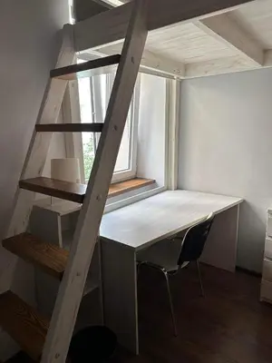 a loft bed with a desk and a chair in a room at Cozy rooms in Old Town and Wawel in Kraków
